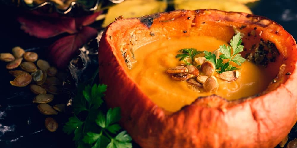 velouté de butternut aux graines de courge rôties servi dans une courge vide